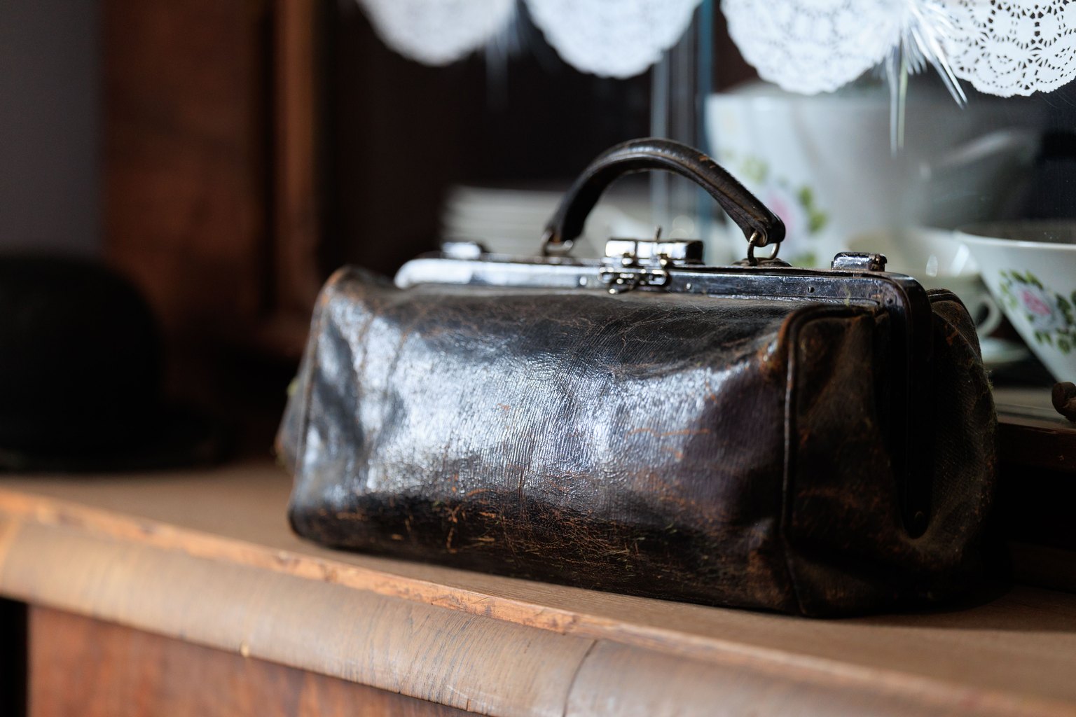 Designer handbags on a cream sofa, their leather faded and dull